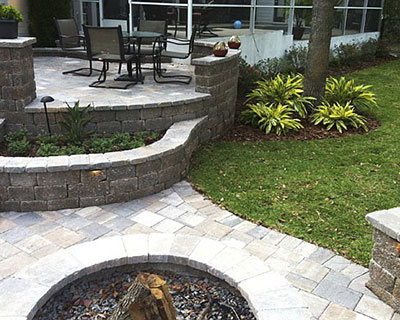 An outdoor living space with a fire pit and natural stone pavers