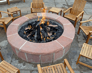 A concrete fire pit surrounded by chairs