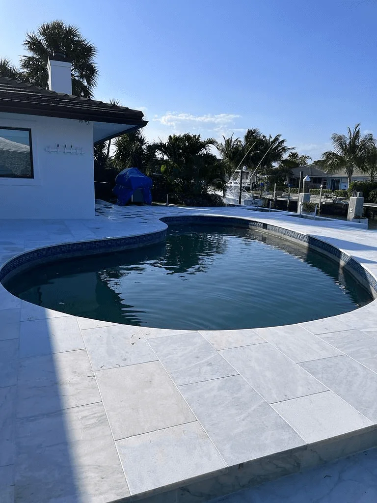 A circular pool with a modern pool deck put in by Palm Beach County pool deck installers