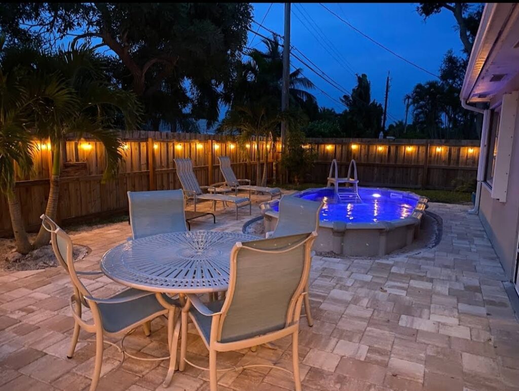 Outdoor patio with four chairs in front of a swimming pool
